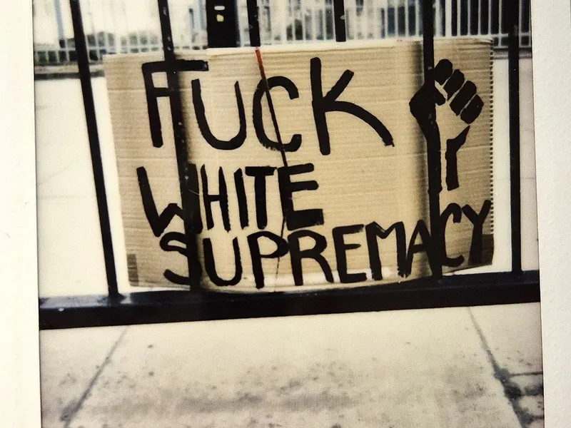 A cardboard sign threaded through railings