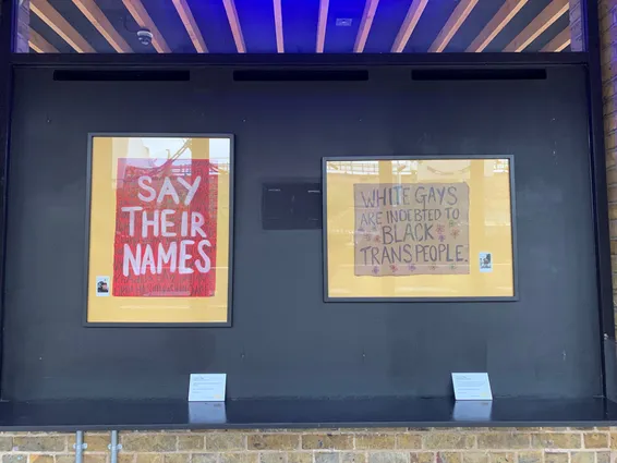 two framed placards on a black wall