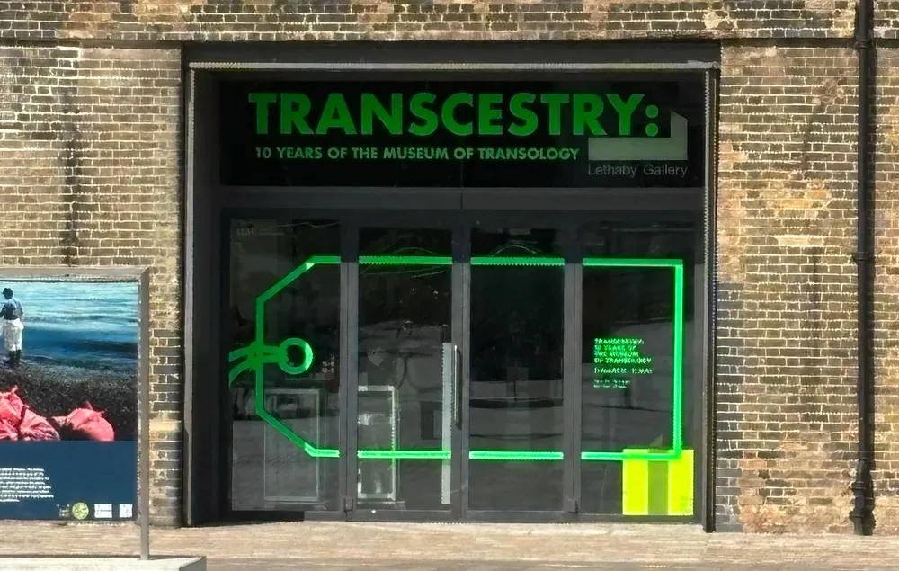 A large set of exhibition space doors with a large luggage tag decal