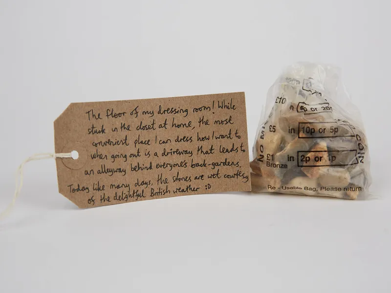 A bag of pebbles with a brown luggage tag attached