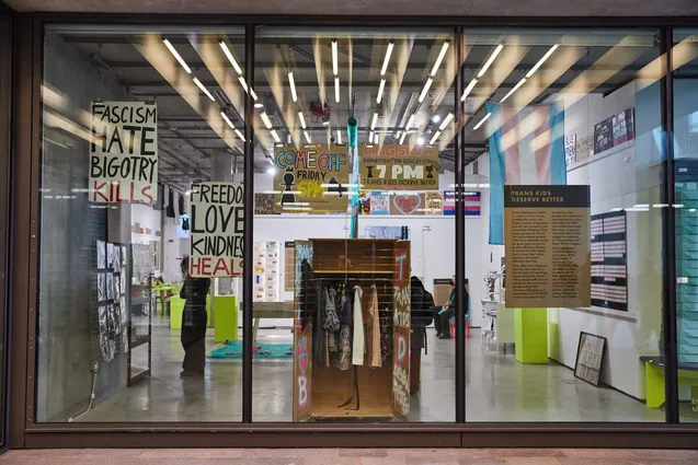 Trans Kids Deserve Better wardrobe seen through a window