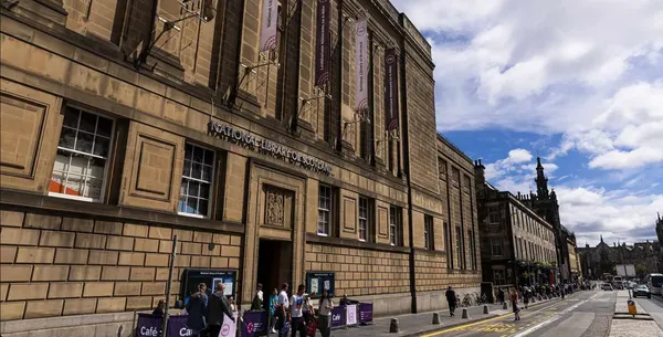 Image of sandstone building with people queing to get in
